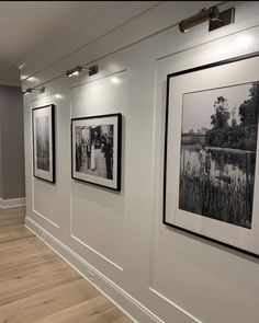 black and white photographs hanging on the wall next to each other in a room with hard wood flooring