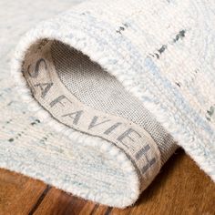 a close up view of the inside of a white and blue rug on a wooden floor