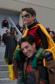 two people dressed up as batman and robin wayne in front of a building with stairs