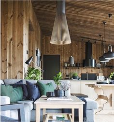 a living room filled with furniture and wooden walls