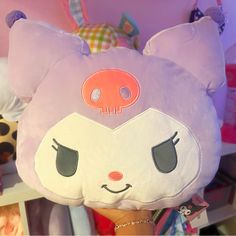 a pink stuffed animal with big ears and eyes on it's head in a room full of toys