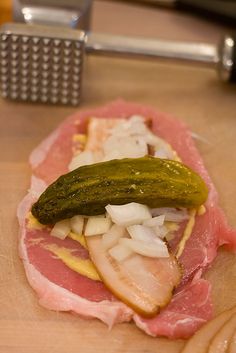 a sandwich with ham, onions and pickles on it