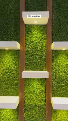 an artificial grass wall with shelves and lights in the shape of rectangles on each side