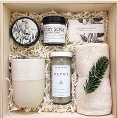 an open box containing body scrubs, candles and other items