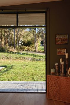 a living room with sliding glass doors that lead to a large yard and grassy area