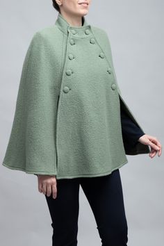 Meet the Margaret Cape: Crafted from 100% virgin wool, this elegant cape combines classic style with modern sophistication. It features a defined collar, a double-breasted front with fabric-covered buttons, and flowing bell sleeves for a dramatic flair. Ideal for transitioning from day to evening, the Margaret Cape offers warmth, comfort, and a polished look that captures timeless elegance. Perfect for anyone seeking a chic, functional wardrobe staple. Wool Cape For Formal Occasions, Formal Wool Cape Outerwear, Elegant Wool Poncho For Workwear, Elegant Long Sleeve Wool Cape, Elegant Cape Poncho For Work, Elegant Wool Capelet For Winter, Fitted Winter Outerwear With Cape Sleeves, Elegant Winter Capelet With Cape Sleeves, Classic Wool Cape For Fall