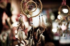 a dream catcher with feathers hanging from it's sides