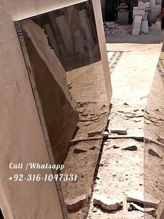 an open door in the middle of a dirt area with rocks and debris around it