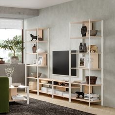 a living room filled with furniture and a flat screen tv on top of a wooden shelf