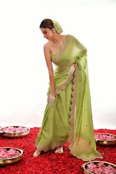 This elegant saree features a light green satin fabric and a stunningly hand-embroidered scalloped border. The gota patti design provides texture and dimension, making this saree a perfect choice for special occasions. Green Art Silk Pre-draped Saree With Embroidered Border, Designer Green Pre-draped Saree With Embroidered Border, Festive Green Pre-draped Saree With Embroidered Border, Green Silk Pre-draped Saree With Gota Work, Elegant Pista Green Dola Silk Pre-draped Saree, Green Raw Silk Saree For Reception, Pista Green Pre-draped Saree With Gota Work, Pista Green Sharara With Embroidered Border, Pista Green Chanderi Sharara With Embroidered Border