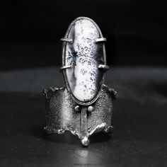 Modern, Brutalist-style Textured Ring. Fully handmade work.  Oxidized 925 Sterling Silver and 999 Fine Silver. The main accent of this ring is a natural Scenic Dendritic Opal. Material: 925 Sterling Silver,999 Fine Silver, Dendritic Opal. The height of the central part is 3.7 cm. Size: Adjustable. Color: Silver, Black. Luxury Brutalist Style Ring, Luxury Brutalist Jewelry With Oxidized Finish, Hand Cast Open Ring Formal Jewelry, Hand Cast Open Ring For Formal Occasions, Unique Oval Rings With Oxidized Finish, Unique Handmade White Bronze Jewelry, Unique Hand Cast Jewelry For Formal Occasions, Unique Handmade Jewelry In White Bronze, Unique Moonstone Ring For Formal Occasions