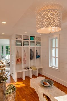 a living room with white walls and wooden flooring, built in shelving units