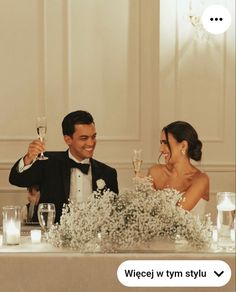 a man and woman sitting at a table with wine glasses