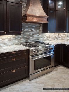 a stove top oven sitting inside of a kitchen next to wooden cabinets and counter tops