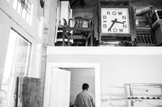 a black and white photo of a man standing in a doorway