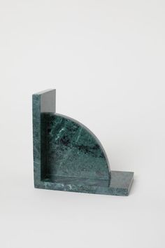 a green marble bookend sitting on top of a white wall