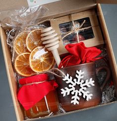 an open box with oranges, honey and other items in it sitting on a table