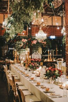 a long table is set up with candles and greenery for an elegant wedding reception