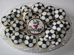 cupcakes in the shape of soccer balls on a platter with we love soccer written on them