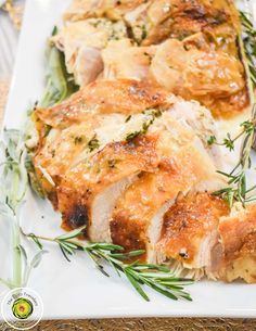 a white plate topped with meat covered in cheese and herbs