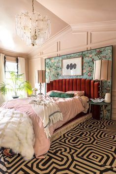 a bedroom with a bed, rug and chandelier