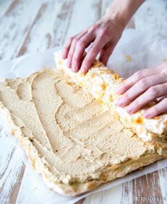 someone is spreading frosting on top of a cake