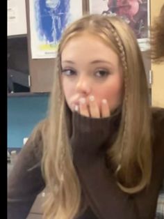 a woman with long blonde hair is taking a selfie