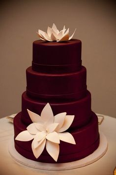 a three tiered cake with white flowers on top