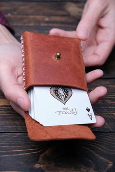 a person is holding a card wallet in their hand