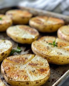 baked potatoes with herbs and seasoning on a baking sheet