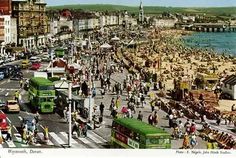 an old photo of a busy city street with lots of people and vehicles on it