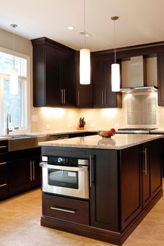 a kitchen with dark wood cabinets and stainless steel appliance in the center island