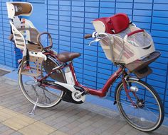 two bikes parked next to each other near a blue wall