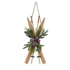 a christmas wreath hanging on the wall with skis and greenery attached to it