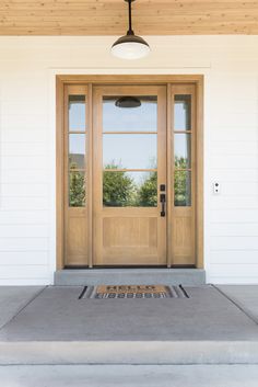 a front door with two sidelights and a light fixture on the outside of it