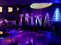 a room with purple and blue lights on the walls that says trina in large letters