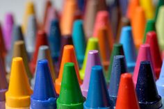 many different colored crayons lined up in rows