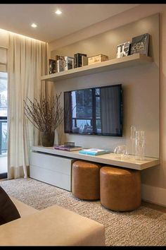 a living room filled with furniture and a flat screen tv mounted on a wall next to a window