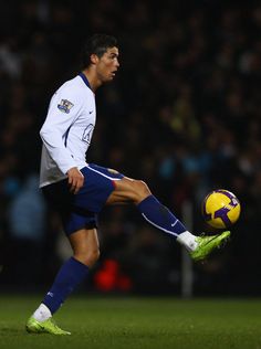 a man kicking a soccer ball on top of a field