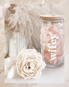 a white flower sitting on top of a table next to a jar filled with candy