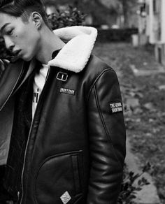 black and white photograph of a young man in a leather jacket talking on a cell phone