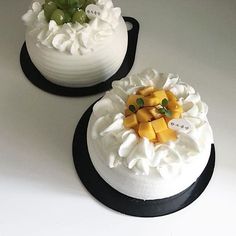 two cakes decorated with fruit on top of each other