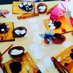 children are sitting at a table making crafts with paper plates and bowls on the table