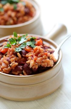 two bowls filled with rice and beans on top of a table