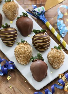 chocolate covered strawberries on a white plate with blue streamers and confetti