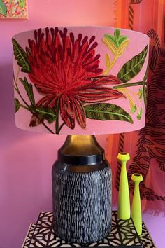 a lamp that is on top of a table next to a vase and other items