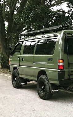 a green suv parked on the side of the road