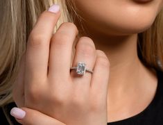 a close up of a person wearing a ring with a diamond on it's finger