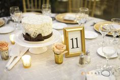 a table topped with a white cake covered in frosting and flowers next to candles