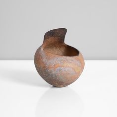 a brown vase sitting on top of a white table